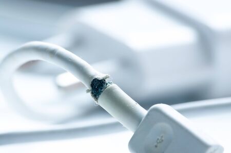 torn charging wire on white background with empty space for text