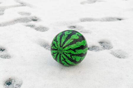 the green ball looks like a watermelon on the snowの写真素材