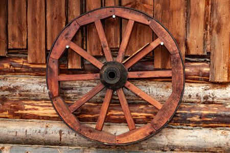wooden cart wheel on the wall of a wooden house