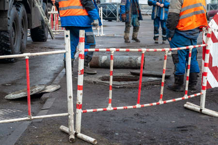 repair of the city heating system. workers in front of an open manholeのeditorial素材