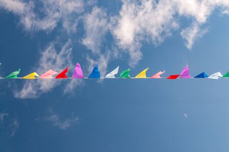 abstract background with multicolored flags and sky with cloudsの写真素材