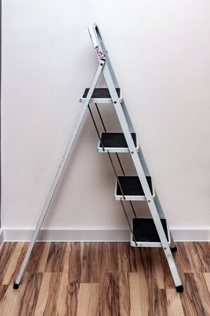 small ladder with four steps standing against the wallの写真素材