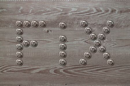 Real natural wood texture with word fix made from screwsの写真素材