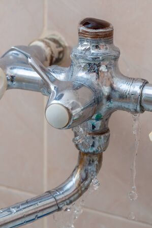 close-up of broken faucet in the bathroom from which the water flows. water leak.の写真素材