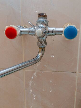 close-up of broken faucet in the bathroom from which the water flows. water leak.の写真素材
