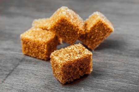 cubes of cane sugar on a gray wooden backgroundの写真素材
