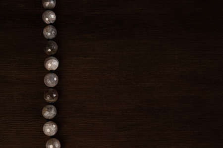 agate beads on a dark wooden background with an empty space for textの写真素材