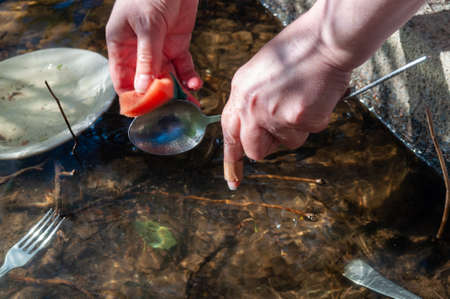 washing dirty dishes in the lake. environmental problems. water supply problem in the village