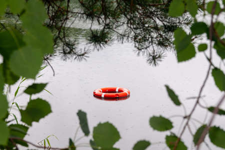 red lifeline in the water. view of the lifeline through the foliageの写真素材