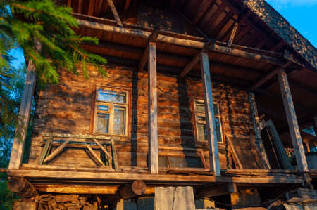 village wooden house in the rays of the setting sunの写真素材