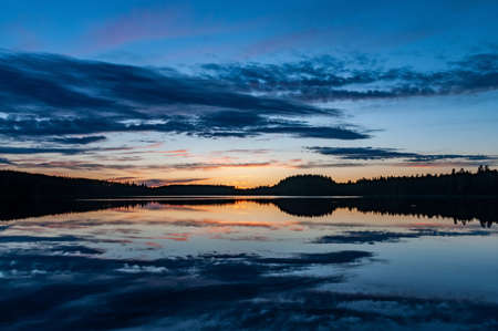 beautiful sunset landscape with clouds reflected in the north lake