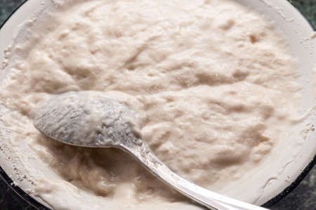 metal bowl with fresh dough prepared for baking