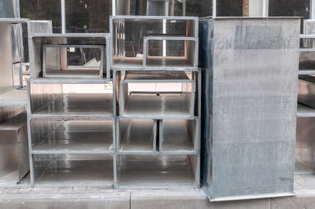 metal structures of various geometric shapes stacked together. Ventilation elements and metal beams stacked on construction siteの写真素材