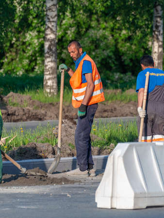 Petrozavodsk, Russia - 8 Juny 2020. road worker with shovel thoughtfully stands