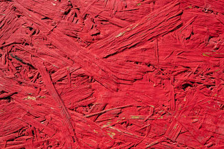 Structure of an old, red painted OSB oriented strand boardの写真素材