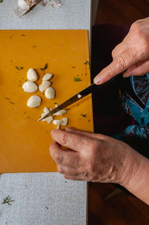 top view of woman finely cuts garlic