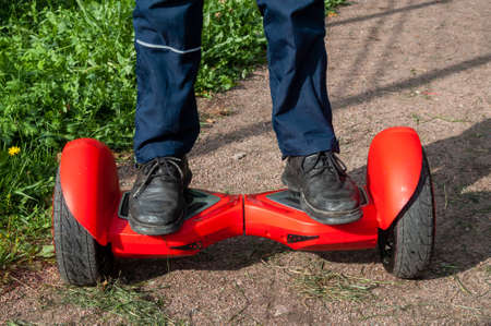 feet on a red dual wheel self balancing electric scooter
