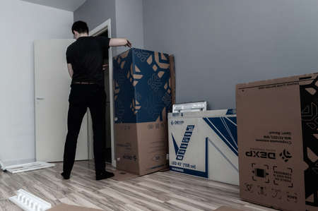 Petrozavodsk, Russia - 2 May 2020. man unpacks a lot of boxes with household appliancesのeditorial素材
