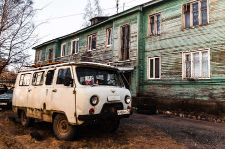 Petrozavodsk, Russia - 17 March 2020. old gray UAZ-452 next to a green two-story barracksのeditorial素材