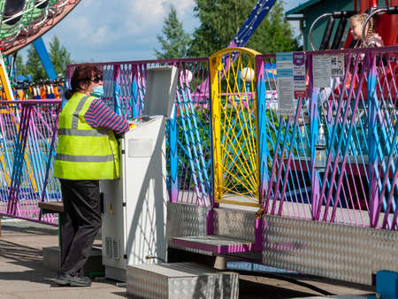Petrozavodsk, Russia - 1 August 2020. amusement park worker in face protective maskのeditorial素材