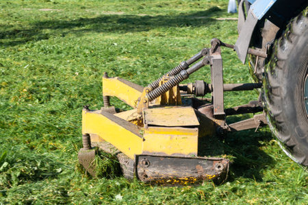 close up of tractor mows the grass on the lawn in the city yard