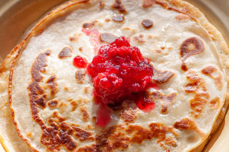 Russian pancakes on plates decorated with berry jam