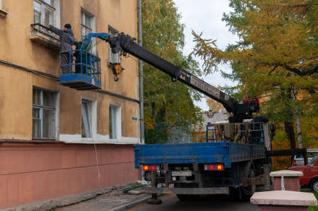 workers on the lift repair the facade of the buildingのeditorial素材
