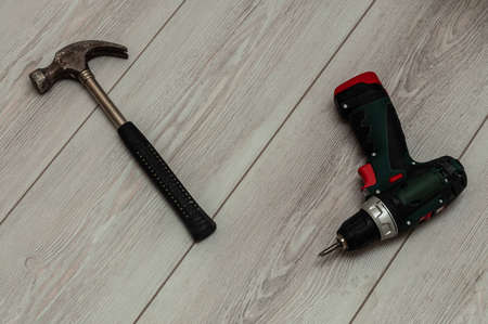 View from above on the hammer and drill lying on a wooden background. High quality photo