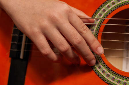 close up of woman's hand playing guitar. High quality photo