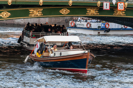 Saint Petersburg, Russia - 20 July 2019. tourist pleasure boat sails under the bridgeのeditorial素材