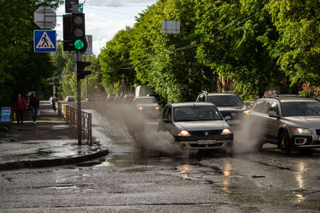 Petrozavodsk, Russia - 3 July 2019. splashes from a car passing through a puddleのeditorial素材