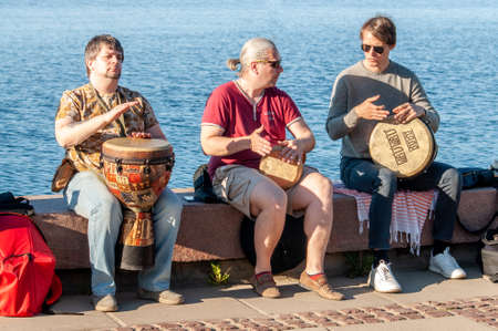 Petrozavodsk, Russia - 13 June 2020. three street musicians playing drums jembe for donationのeditorial素材