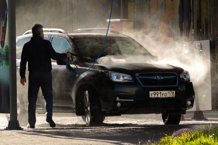 a man washes his car at a self-service car washのeditorial素材