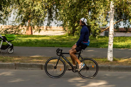 a cyclist with headphones rides on the road without holding the steering wheelのeditorial素材