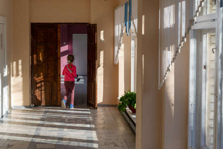 a girl runs down the hallway of the school.