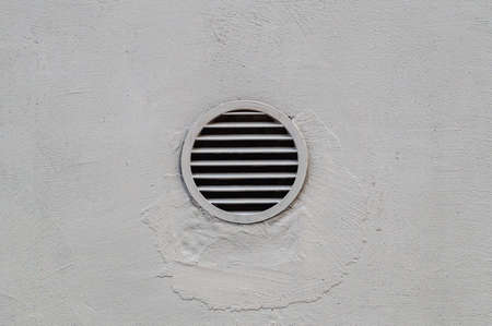 ventilation grate on a grey concrete wall