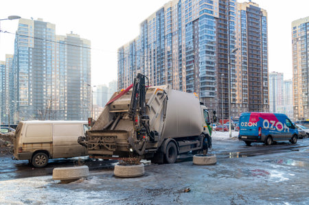 Saint Petersburg, Russia - 15 March 2022. garbage truck among high-rise residential buildings