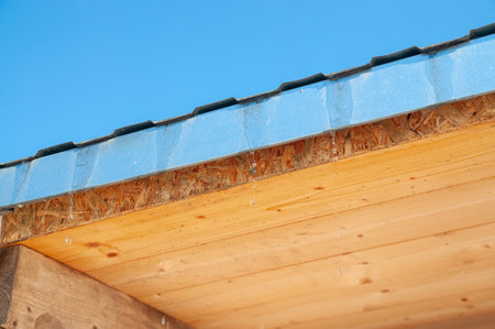 drops from the roof of a wooden houseの写真素材