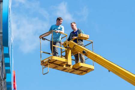 two workers on the aerial work platform against the skyのeditorial素材