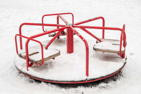 small carousel on the playground on a winter day