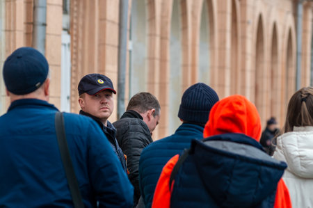 a policeman in a uniform cap in a crowd of peopleのeditorial素材