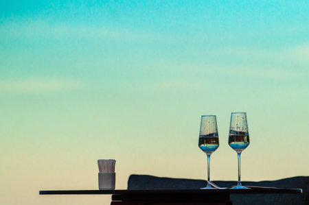 two glasses on the table against the background of the evening skyの写真素材