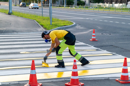 a road worker draws the markings of a pedestrian crossingのeditorial素材