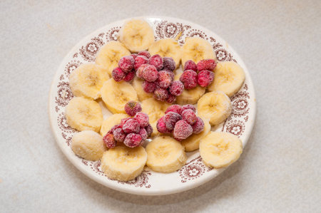 frozen bananas and strawberries on a plateの写真素材