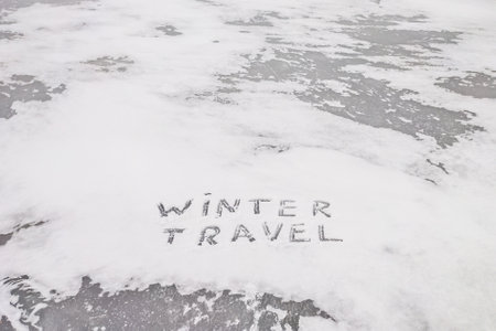 Winter snow-covered background with the inscription winter travel.の写真素材