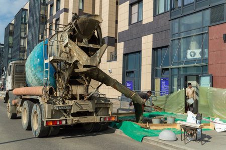 Saint Petersburg, Russia - 14 May 2023. Workers use concrete from concrete mixer truckのeditorial素材