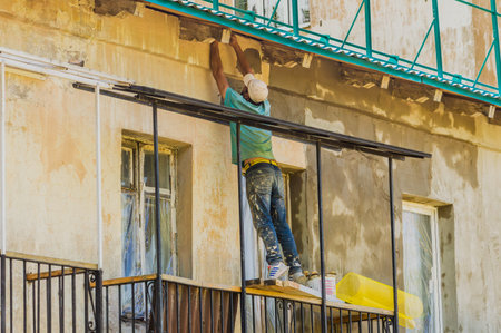 A worker repairs the facade of a buildingの写真素材