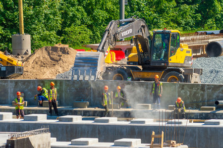 Petrozavodsk, Russia - 14 June 2023. Workers and excavator at the construction siteのeditorial素材