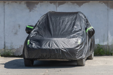 A car covered with a black coverの写真素材