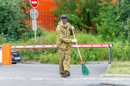 Petrozavodsk, Russia - 12 July 2023. Man sweeping the street with a broom